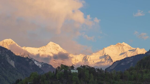 Timelapse Sunset over mountains. View on Jungfraujoch from Interlaken. Clouds moving over mountains. Interlaken, Bernese Oberland, Canton Bern, Switzerland.