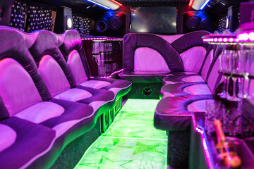 The interior of a luxury limousine illuminated in purple and green. Vehicle for party, wedding. - obrazy, fototapety, plakaty