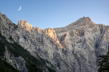 Vrata Valley views alpine Jullian peaks in sunset light with the moon in the sky.