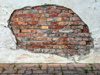 Damages Italian stucco wall exposing bricks