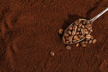 Coffee beans on spoon on coffee background