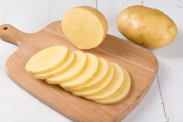 Raw potatoes on wood background
