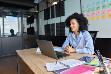 Successful African American businesswoman sitting at desk having working videoconference on yearly...
