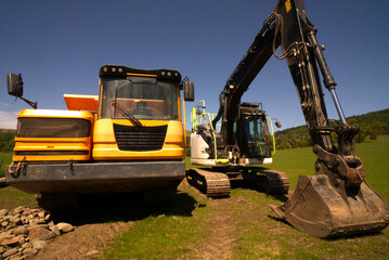 Excavators are heavy construction equipment consisting of a boom, dipper, bucket and cab on a rotating platform known as the "house". The house sits atop an undercarriage with tracks or wheels.