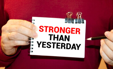 stronger than yesterday white chalk text on a vintage slate blackboard.