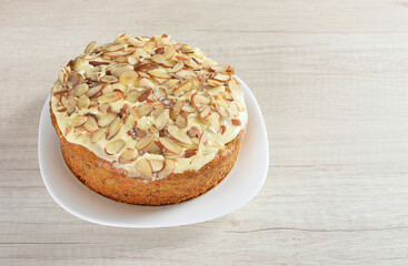 Carrot cake with almonds, on a white plate.