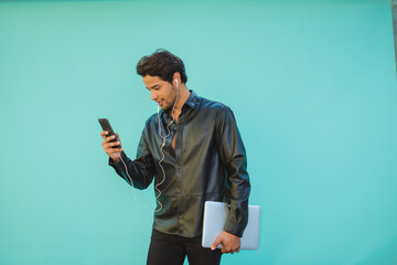 Businessman with laptop having video call on smartphone