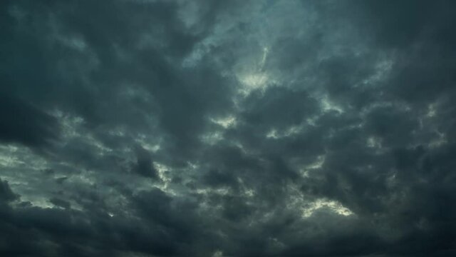 Lacerated storm clouds slowly and heavy float on the sky.