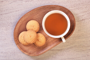 Coconut cookies with tea on the wooden tray 