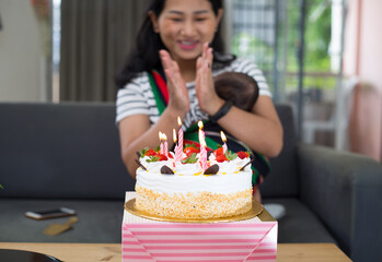 Asian young mother celebrating her birthday at home with her baby. 