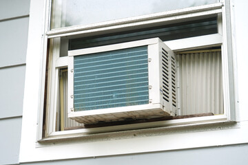 old air conditioner installed on rustic house window
