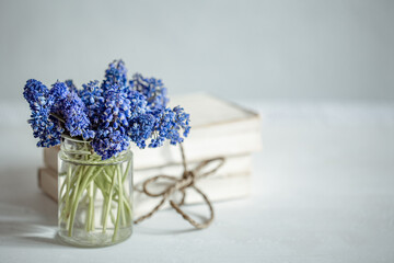 A miniature bouquet of muscari flowers in a transparent vase copy space.