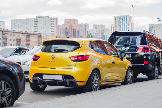 Rear view of yellow Renault Clio RS IV parked on street