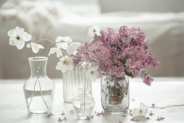 Close-up of bouquets of spring flowers in vases on a blurred background.