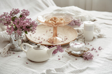 Home composition with spring flowers, milk and cookies in bed.