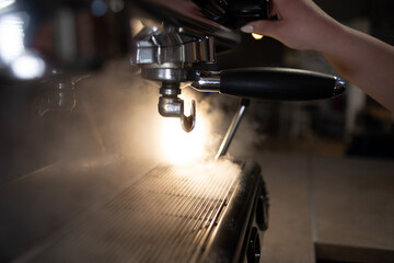 coffee machine makes steam in a cafe. smoke is coming out of the coffee maker. concept of the process of making coffee.
