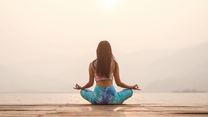 Yoga on the beach. Happy asian woman wearing Tie Dye bikini practicing yoga. Young healthy...
