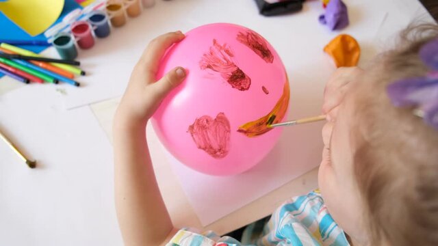 Child drawing pattern of paints fun smile on the balloon. Fun toy. Arts  crafts concept. art learning and education
