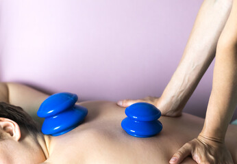 The postpartum doula placed vacuum silicone cups on the woman's back. Postpartum recovery of a...