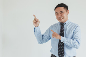 Portrait of happy sales man wearing blue shirt and tie pointing on empty space for advertisement