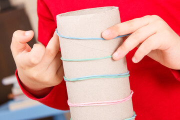 Preschooler playing with rubber erasers and cardboard roll. Development of kids motor skills,...