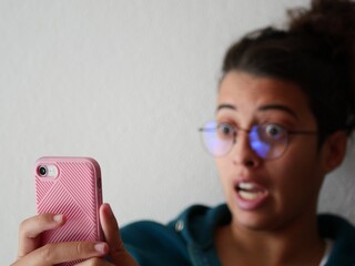 Personne qui tient un téléphone rose apprend une incroyable nouvelle 