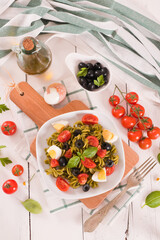Fototapeta na wymiar Fusilli pasta with cherry tomatoes, eggs and black olives.