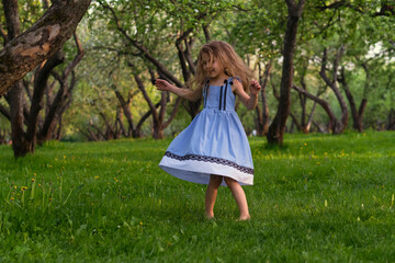 little girl runs barefoot on the grass. happy child on a hot summer day.