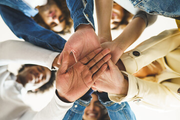 Obraz premium Hands of a multi-ethnic group of friends joined together as a sign of support and teamwork.