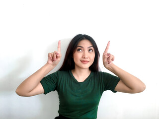 Happy and smile face with smile of young Asian girl in green shirt with hand point on above empty space.