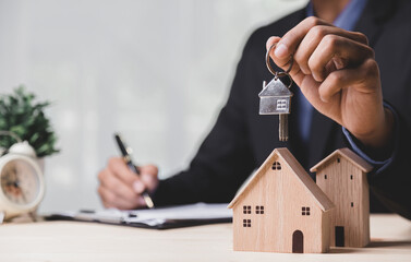 Business hand holding home with Buy or Rent, copy space. Property investment and house mortgage...