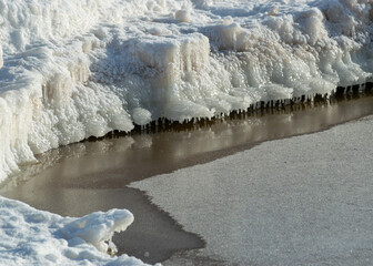 winter landscape by the sea, snowy, interesting ice shapes on the sea shore, dunes covered with a...