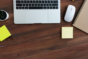 Top view of Business equipment Computer laptop notebook,post it,sale report mouse and coffee on wooden table,Flat lay business concept with copy space