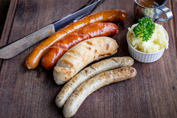 Grilled sausages and mashed potato on wooden boar