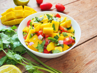 Mango salsa salad bowl with fresh tomato,coriander and lime.