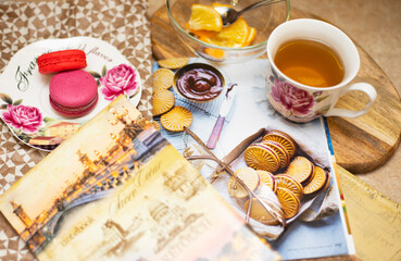 A cup of tea, macarons, a journal and a notebook. Tea break, time for relaxation and thinking about plans. Making a to-do list for the day.