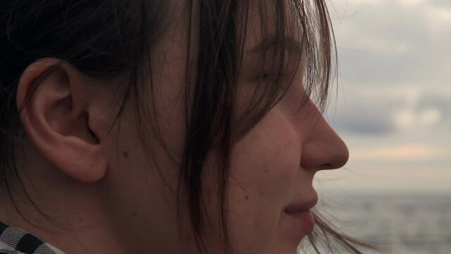 Close up portrait of a young woman looking at a beautiful seascape. 4k footage