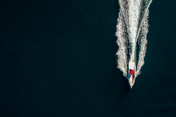 Drone shot of a white motor boat in deep blue sea from above. sightseeing vacation in Turkey.