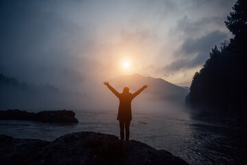 Blue evening mist over mountain river on the background of wooded hills and overcast sky. Man...