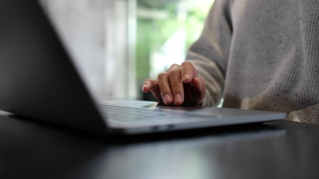 Closeup a woman working and touching on laptop computer touchpad on the table