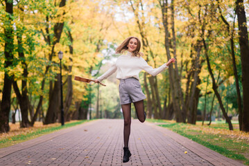 Beautiful woman playing ukulele guitar at outdoor in autumn forest