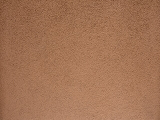Texture. The wall is covered with light brown concrete plaster. Background.