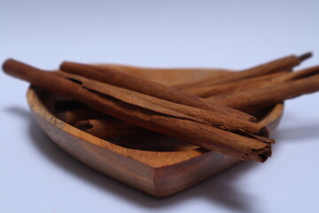 stacks of cinnamons in a heart shaped wooden bowl