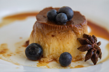 delicious flan with caramel and blueberries on the plate