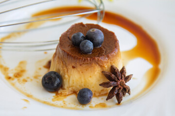 delicious flan with caramel and blueberries on the plate