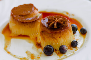 delicious flan with caramel and blueberries on the plate