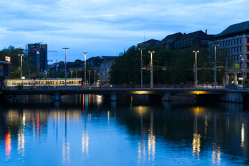 Obraz premium Railway station bridge at City of Zurich by night at summertime with dramatic sky background. Photo taken June 5th, 2021, Zurich, Switzerland.