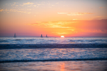 Naklejka na ściany i meble Sunset at the sea. Sunrise at beach. Colorful ocean beach sunrise.