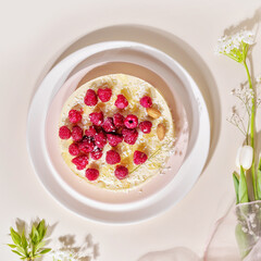 Home made, raspberry, almond cake on a white plate on a pink background. Sweet pastries with almond flour are gluten-free, low in carb. Keto diet. Healthy dessert. Flat lay