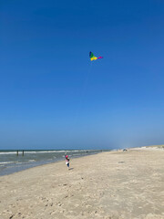 A person flying a kite on the beach.